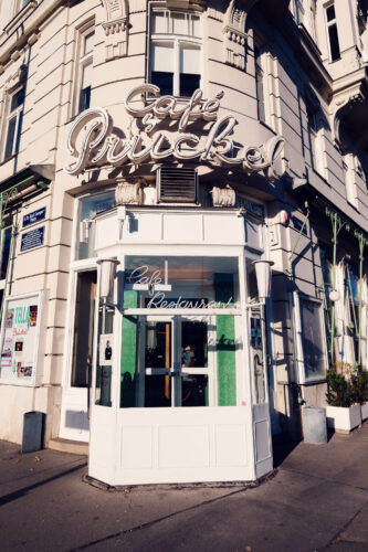 Inviting entrance of Café Prückel, framed by original 1950s signage and modernist details.