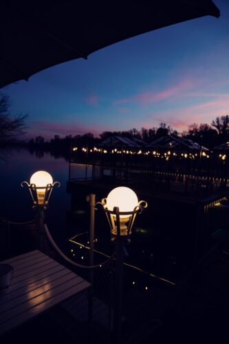 Sunset dining at Das Bootshaus terrace, where contemporary design meets nature's evening show.