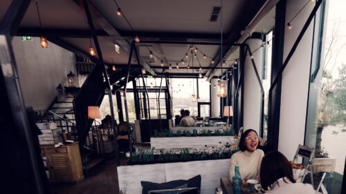 Morning atmosphere at Das Glashaus, where early light streams through glass panels creating magical shadows across breakfast tables.