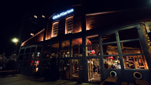 Industrial-chic facade of Gleis//Garten Vienna, where historic railway architecture meets contemporary gastronomy.