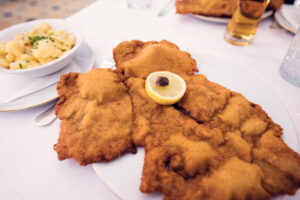 The famous oversized schnitzel at Meissl & Schadn, crispy and tempting on white porcelain.