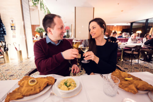 Romantic moment at Meissl & Schadn: Adriana and Mario toasting with wine and beer as their perfect schnitzel arrives.