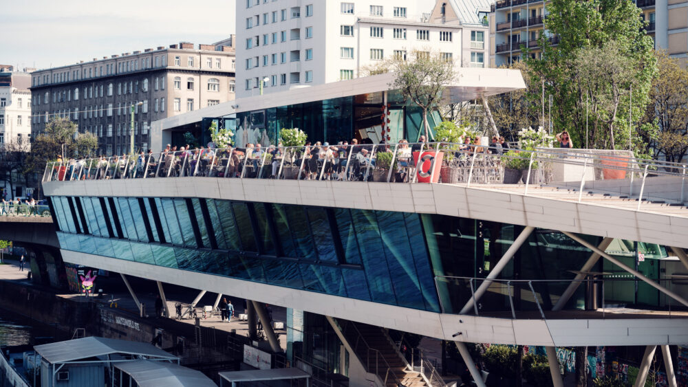 Modern facade of Motto am Fluss catching golden rays.