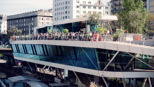 Modern facade of Motto am Fluss catching golden rays.