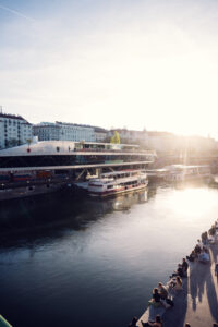Sun-drenched view of Motto am Fluss, where contemporary design meets waterfront dining in Vienna.