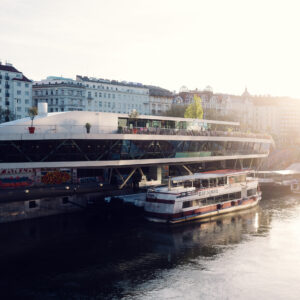 Motto am Fluss' distinctive ship-like architecture gleaming in the sunlight, perfectly positioned along Vienna's Danube Canal.