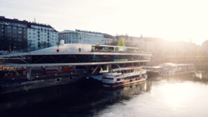 Motto am Fluss' distinctive ship-like architecture gleaming in the sunlight, perfectly positioned along Vienna's Danube Canal.