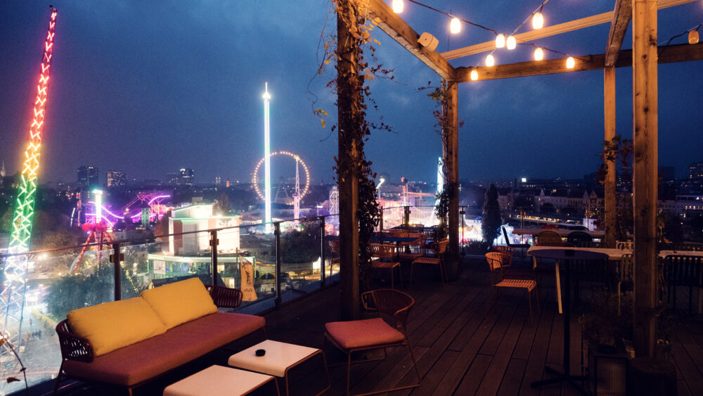 ZOKUs Rooftop Bar in der Dämmerung, wenn Lichterketten eine magische Atmosphäre über den Dächern Wiens schaffen.