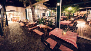 Vintage lanterns at Martin Sepp cast warm light across traditional checkered tablecloths.