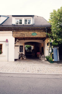 Rustic wooden gates leading into Martin Sepp's Heuriger, where centuries of Viennese wine culture come alive.