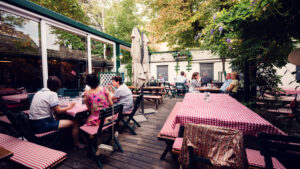 Intimate garden setting at Martin Sepp, where vintage wine barrels meet flowering pergolas.
