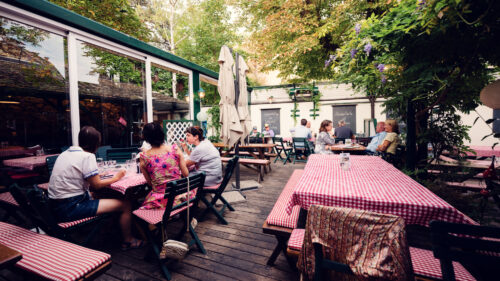 Intimate garden setting at Martin Sepp, where vintage wine barrels meet flowering pergolas.