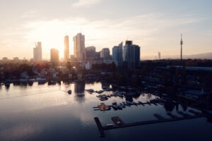 Wiener Stadtsilhouette beim Sonnenuntergang von der Erholungszone Alte Donau mit warmen Abendfarben.