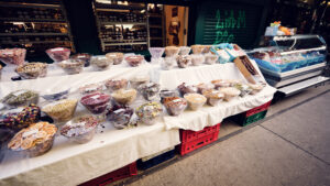 Abundant nut and dried fruit stall at Naschmarkt, showcasing freshly roasted almonds, walnuts, pistachios, and exotic varieties.