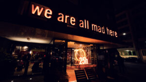 The modern doorway with its distinctive signage and warm lighting creates an inviting gateway to sophisticated dining.