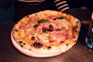 Wood-fired Neapolitan pizza at Ribelli, showcasing perfectly charred crust and premium Italian ingredients.