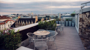 Plant-surrounded seating nooks at Atmosphere Rooftop Bar's terrace creating natural photo opportunities.