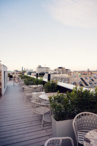 Atmosphere Rooftop Bar Vienna's outdoor lounge area with cushioned rattan furniture and city views.