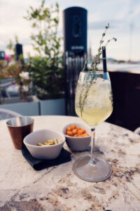 Cocktail presentation at Atmosphere Rooftop Bar with Vienna city backdrop.