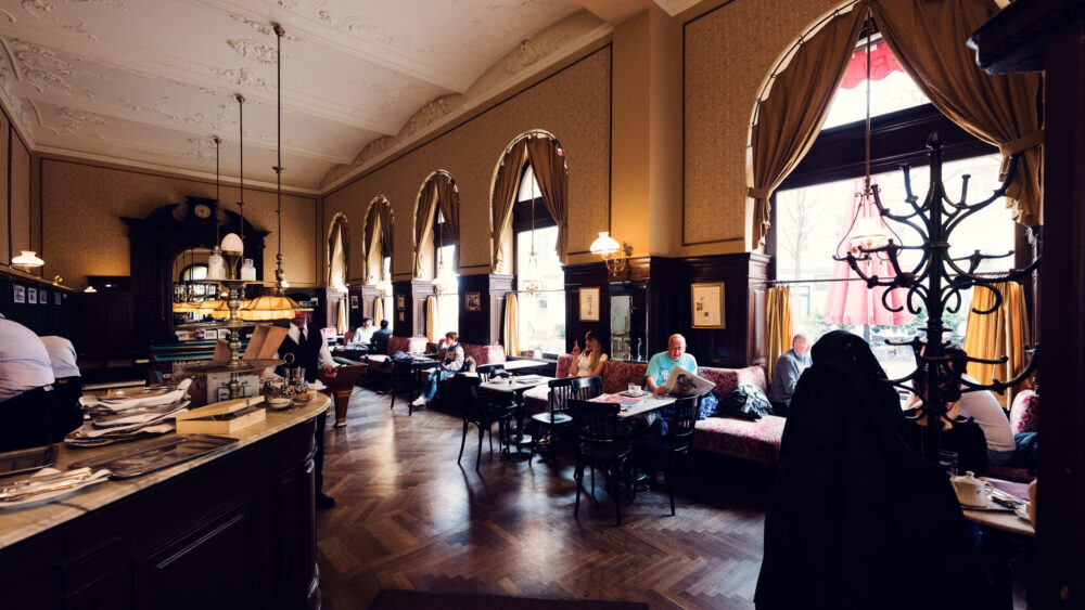 Evening atmosphere at Café Sperl illuminated by original chandeliers.