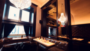 Corner lounge area in Kleinod Bar with vintage leather armchairs and marble side tables.