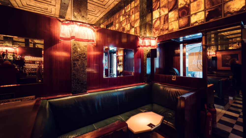 Intimate seating nooks at Loos American Bar, where marble-topped tables and original mirrors create sophisticated atmosphere.