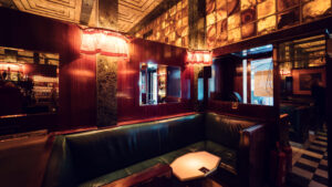 Intimate seating nooks at Loos American Bar, where marble-topped tables and original mirrors create sophisticated atmosphere.