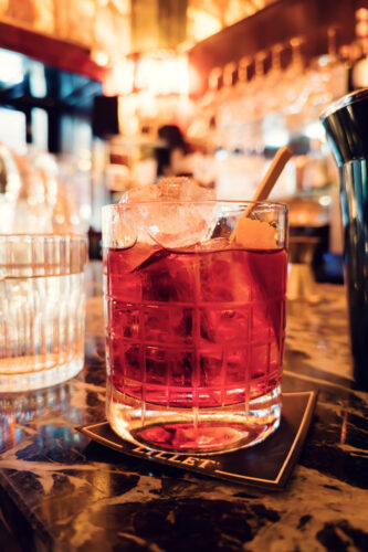 Cocktail at Loos American Bar, perfectly presented in traditional glassware against historic marble backdrop.