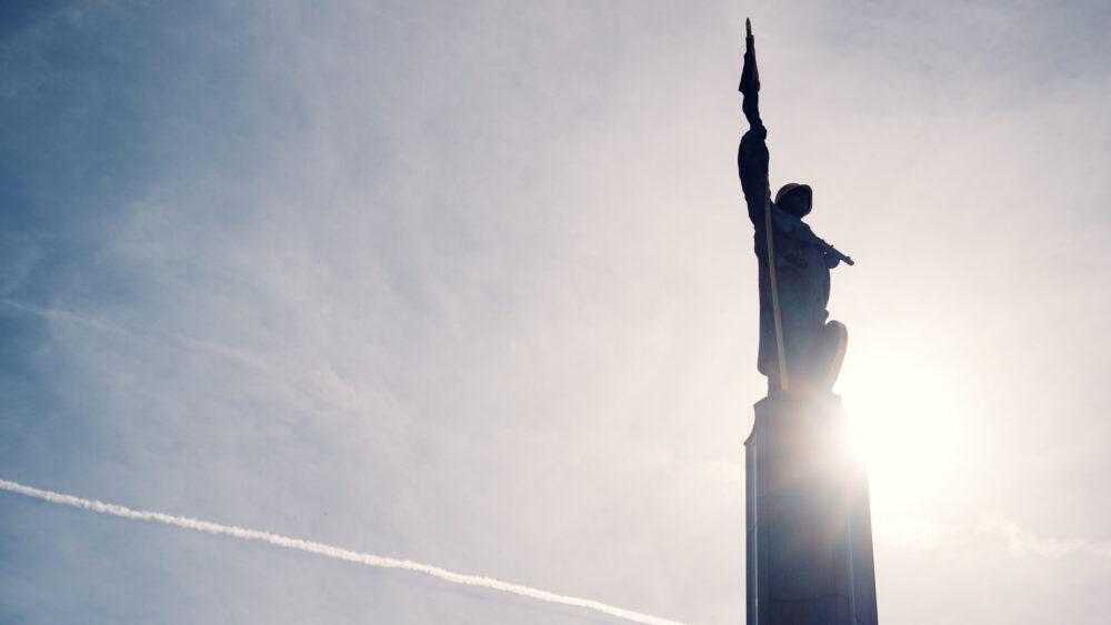 Close-up of the golden-helmeted Soviet soldier statue at Schwarzenbergplatz Vienna bathed in sunset light.