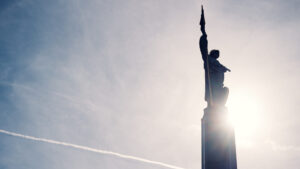 Close-up of the golden-helmeted Soviet soldier statue at Schwarzenbergplatz Vienna bathed in sunset light.