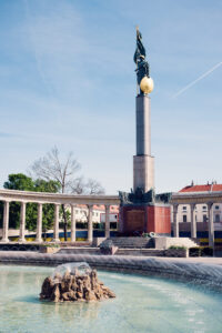 The towering 20-meter high Soviet War Memorial (Heldendenkmal der Roten Armee) at Schwarzenbergplatz Vienna, featuring a golden-helmeted soldier statue atop a marble column.