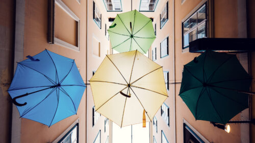 Light streaming through suspended umbrellas at Sünnhof passage.