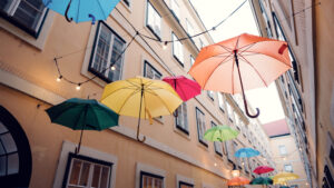 Detail of suspended umbrellas against historic architecture at Sünnhof passage.