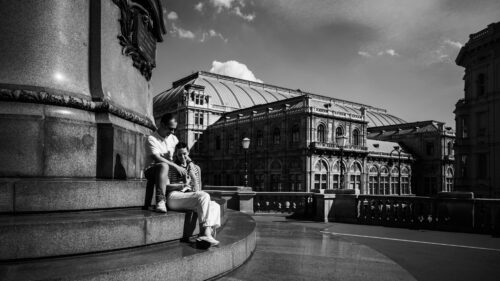 Adriana and Mario posing at historic Albertina palace Vienna with Habsburg imperial architecture featuring classical white stone facade and decorative palace elements.