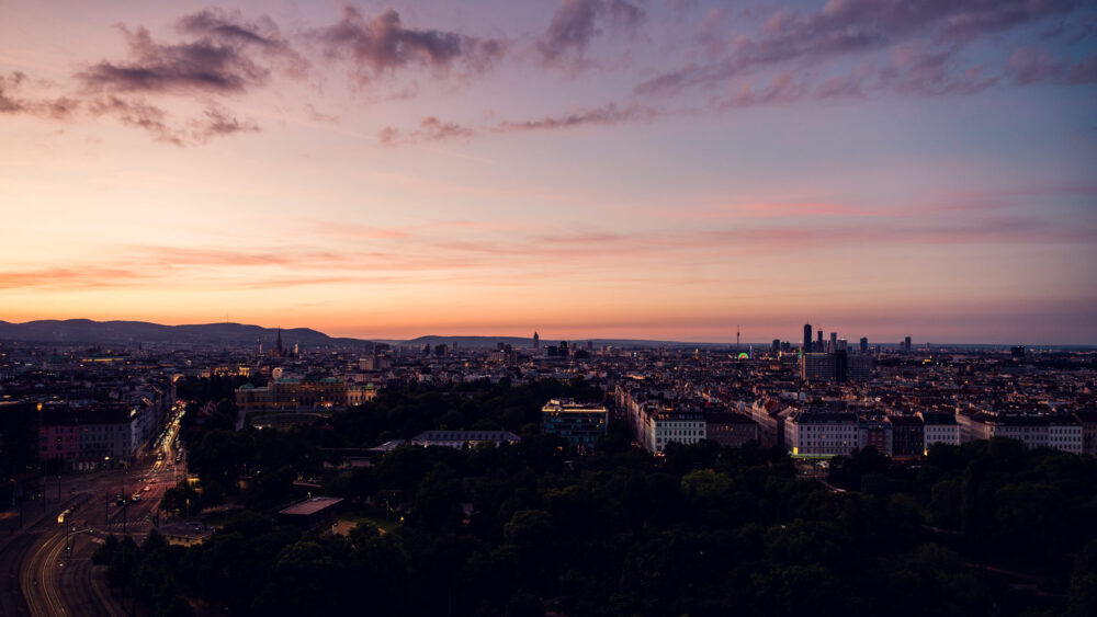 Evening sunset panorama from Aurora Rooftop Bar Vienna, elevated city views with warm golden light illuminating Vienna's architectural landmarks.