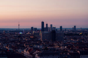 Golden hour sunset view from Aurora Rooftop Bar Vienna Austria, panoramic evening cityscape with warm lighting illuminating Vienna's architectural features.