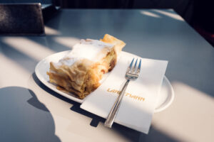 Café Landtmann's signature apple strudel (Apfelstrudel) served on traditional porcelain plate.