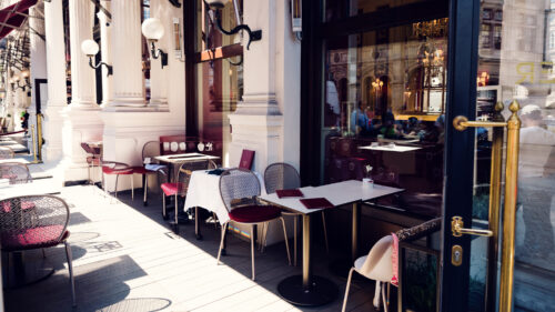Charming outdoor terrace of Café Sacher Vienna with traditional café furniture and views of the historic city center.