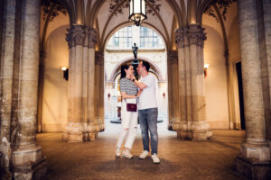 Portrait of Adriana and Mario at Ferstl Passage Vienna featuring symmetrical marble columns and restored 19th-century architectural details.
