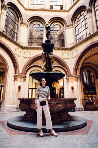 Adriana positioned at the ornate fountain in Ferstl Passage Vienna.