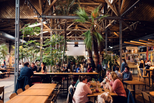 Gleis//Garten Vienna's communal dining tables encouraging social interaction among visitors while enjoying international cuisine from multiple vendors.