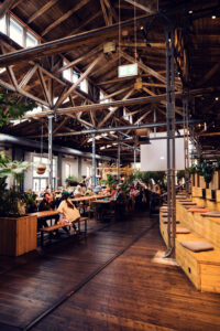 Interior of Gleis//Garten Vienna showcasing the preserved industrial heritage of the former railway carriage shed.