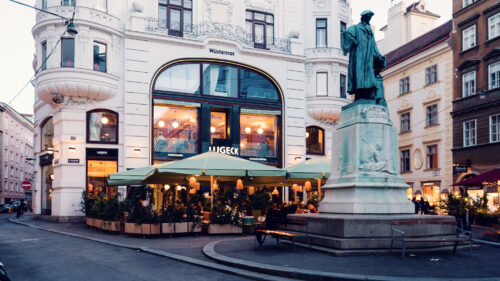 Outside view of Lugeck Figlmüller restaurant building, historic Viennese architecture with traditional storefront design and outdoor seating area in Innere Stadt.