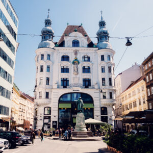 Street view of Lugeck Figlmüller´s exterior, historic Viennese building architecture with traditional restaurant facade and outdoor dining setup in city center.
