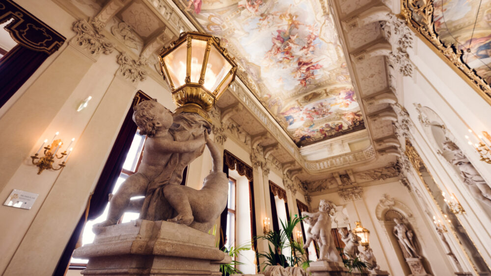 Palais Kinsky Wien baroque interior antechamber featuring elaborate stucco decorations gilded details and classical Austrian palace room design.