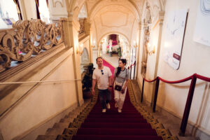 Adriana and Mario posing at Palais Kinsky Vienna baroque palace staircase.