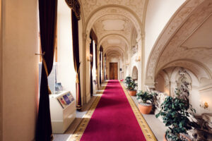 Palais Kinsky Vienna baroque interior corridor with marble columns classical arches and ornamental decorations Habsburg era palace hallway design.