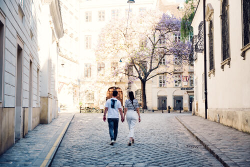 Adriana and Mario walking near Vienna Clock Museum (Uhrenmuseum) in Vienna's First District, historic Inner City street scene.
