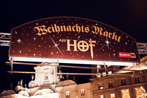 Historic Am Hof square hosting Christmas market with surrounding palace buildings.