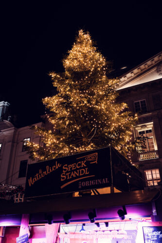 Festive light decorations at Christkindlmarkt Am Hof with baroque architecture backdrop.